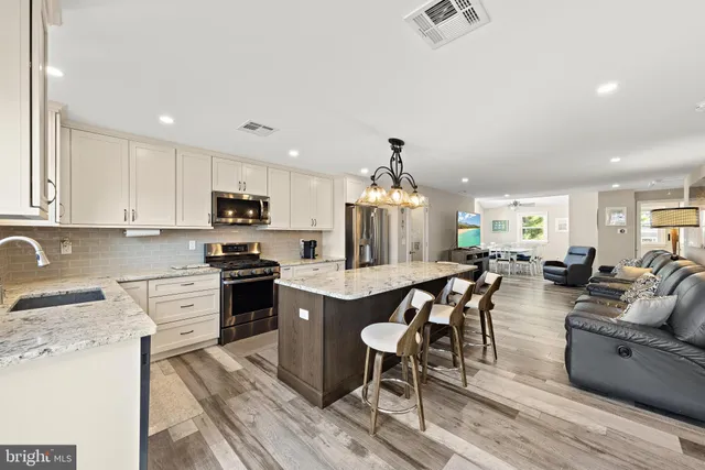 a view of a kitchen with cabinets stainless steel appliances and a dining table