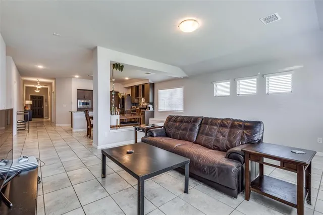 a living room with furniture and a dining table with kitchen view
