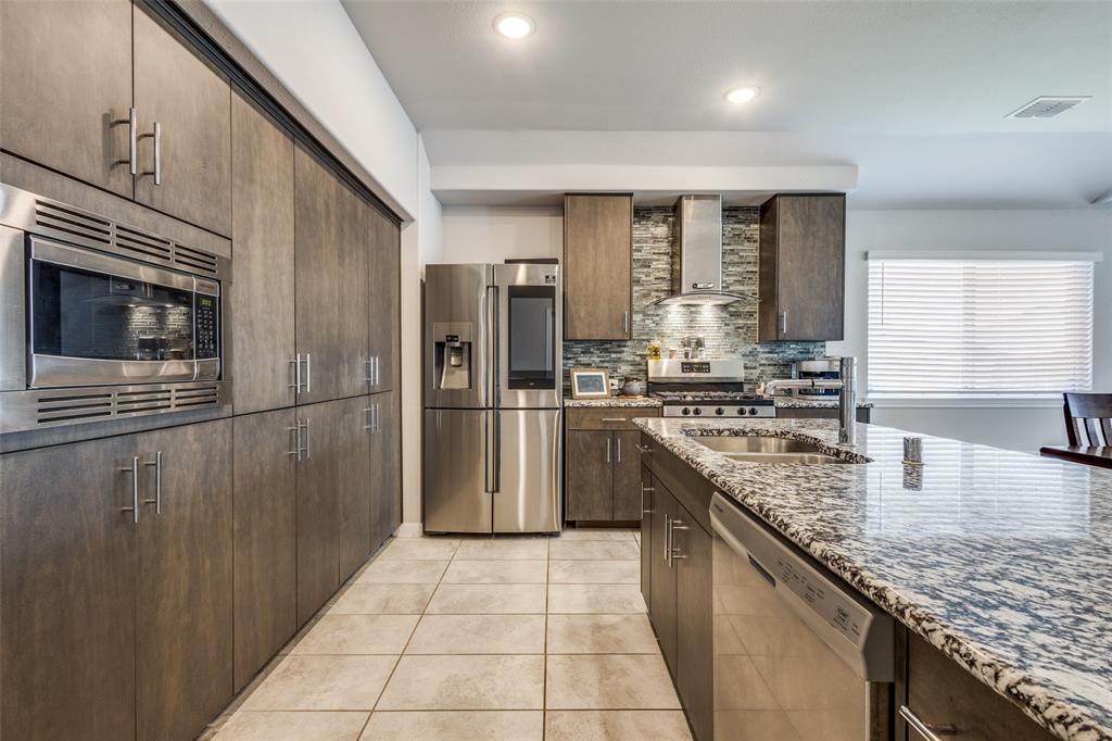 1404 Rosebush Road Aubrey, TX 76227 - Photo 6 of 25 a kitchen with stainless steel appliances granite countertop a sink stove and refrigerator