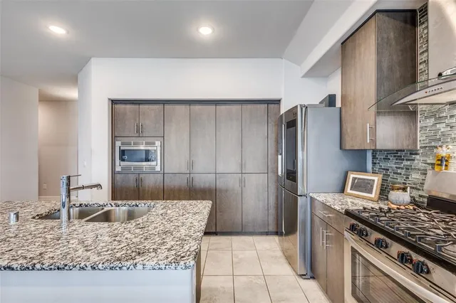 a kitchen with stainless steel appliances granite countertop a sink stove and refrigerator