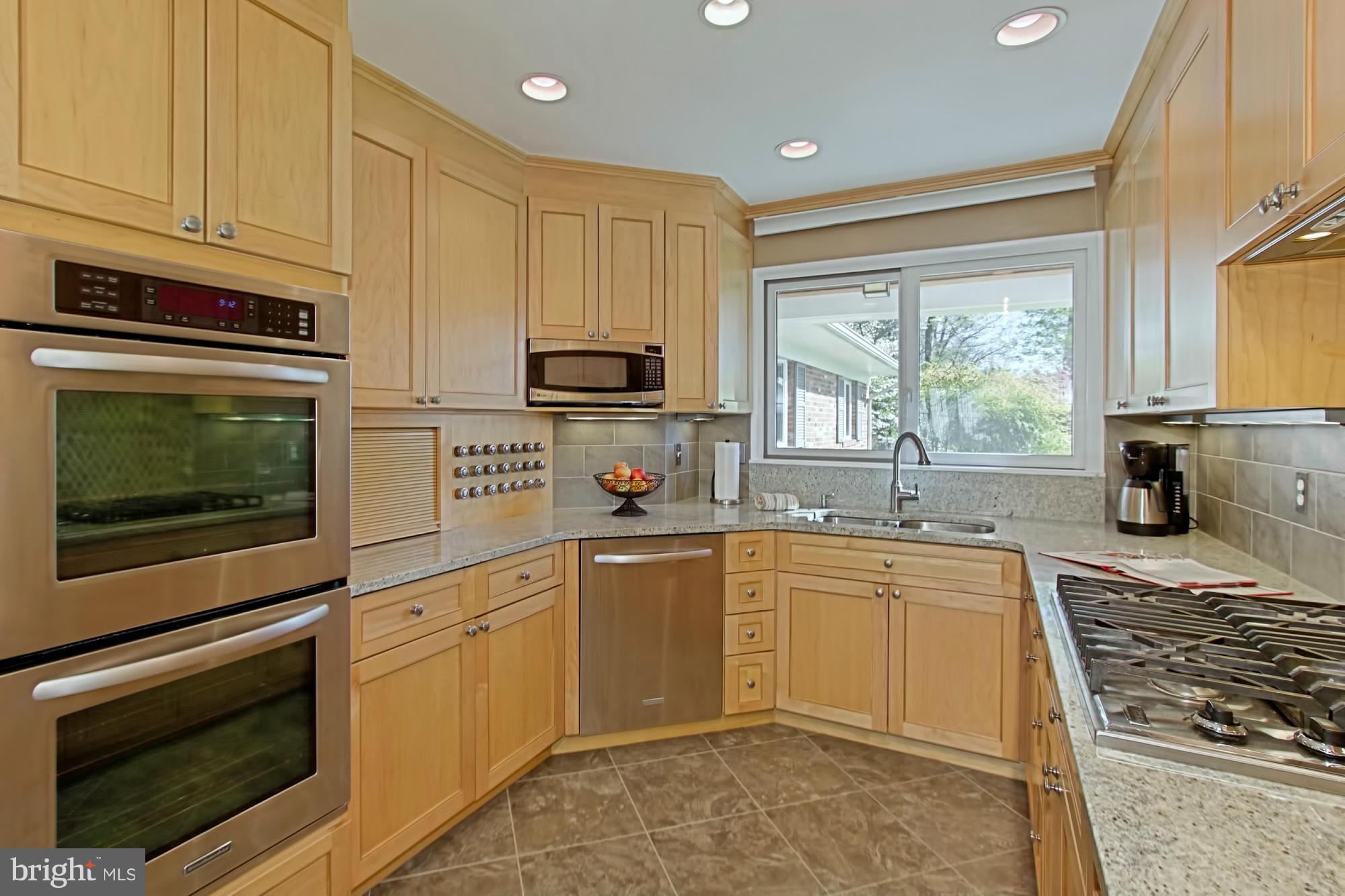 3900 Chesterbrook Road Arlington, VA 22207 - Photo 10 of 30 a kitchen with kitchen island granite countertop a sink cabinets stainless steel appliances and a window