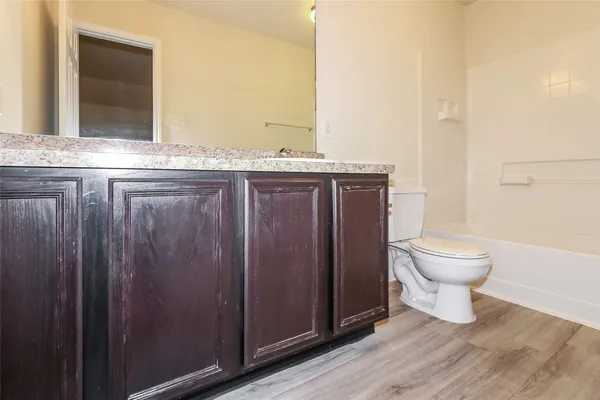 a bathroom with a granite countertop sink toilet and mirror