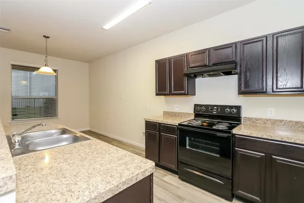 a kitchen with kitchen island granite countertop stainless steel appliances and wooden cabinets
