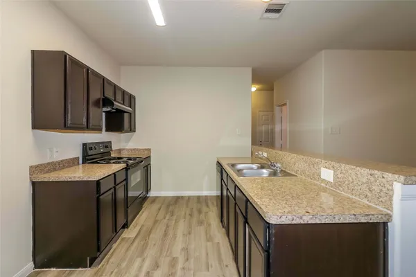 a kitchen with granite countertop stainless steel appliances a sink stove top oven and microwave