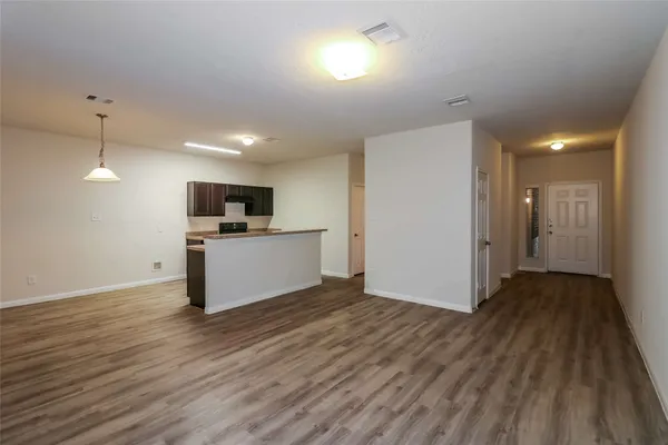 a view of a kitchen with a sink and dishwasher a refrigerator with wooden floor