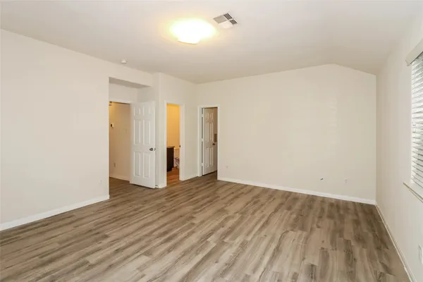 a view of an empty room with wooden floor