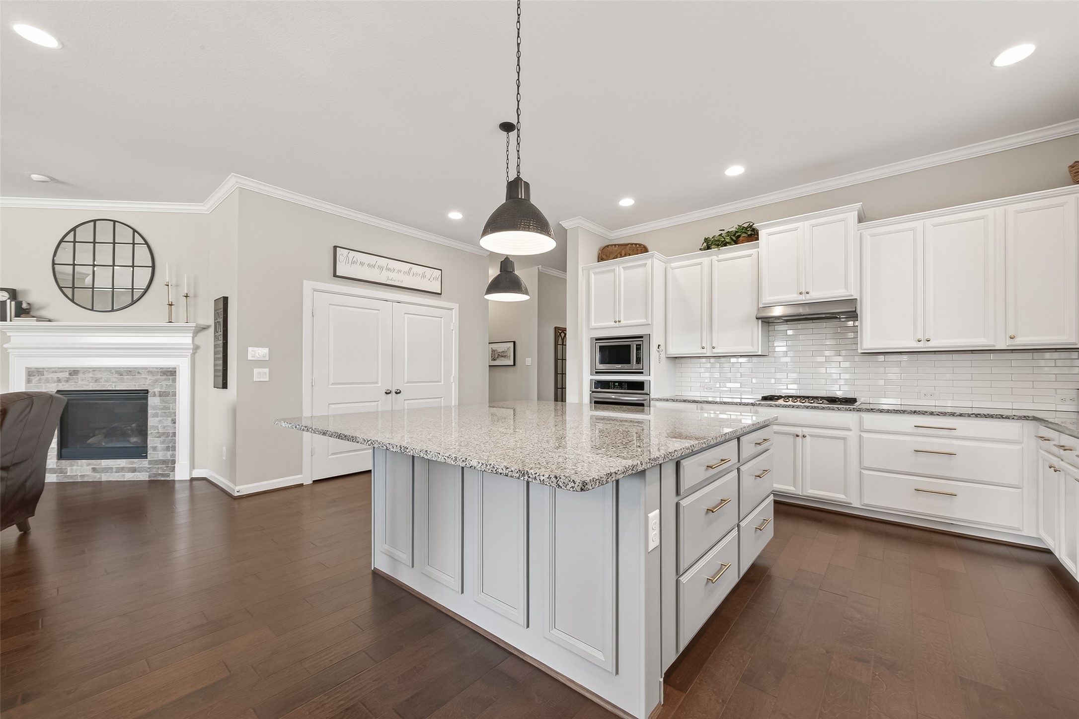 1307 Layla Sage Loop Richmond, TX 77406 - Photo 15 of 50 The chef’s kitchen showcases a stunning oversized island with granite countertops, seating for up to six, decorative molding, and elegant pendant lighting.