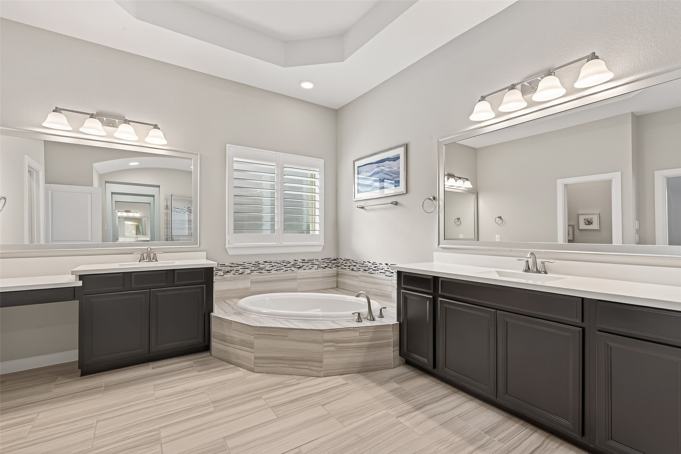 1307 Layla Sage Loop Richmond, TX 77406 - Photo 40 of 50 The spa-inspired primary bath features:
• Elegant double entry doors
• Tray ceilings
• Corner soaking tub
• Separate dual vanities (one with upgraded seating nook)
• Framed mirrors
• Large glass-enclosed shower with built-in bench
• Super Luxe walk-in closet with abundant storage and hanging space