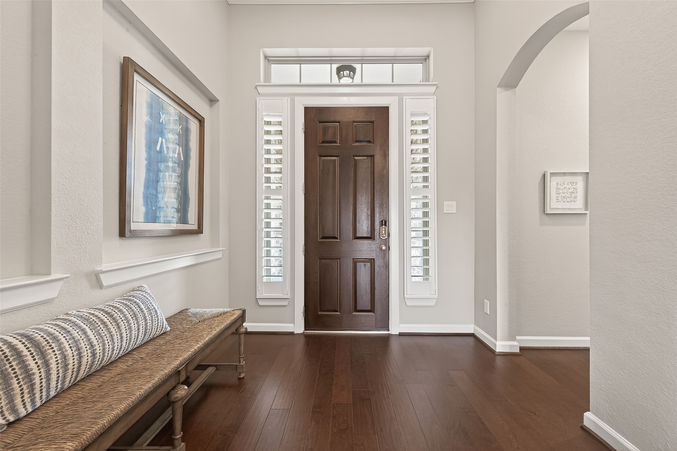 1307 Layla Sage Loop Richmond, TX 77406 - Photo 10 of 50 Step inside to an impressive open foyer with soaring ceilings, setting the tone for the refined finishes and spacious design throughout. Elegant upgraded wood flooring flows through the main living areas, complemented by timeless plantation shutters and abundant natural light.