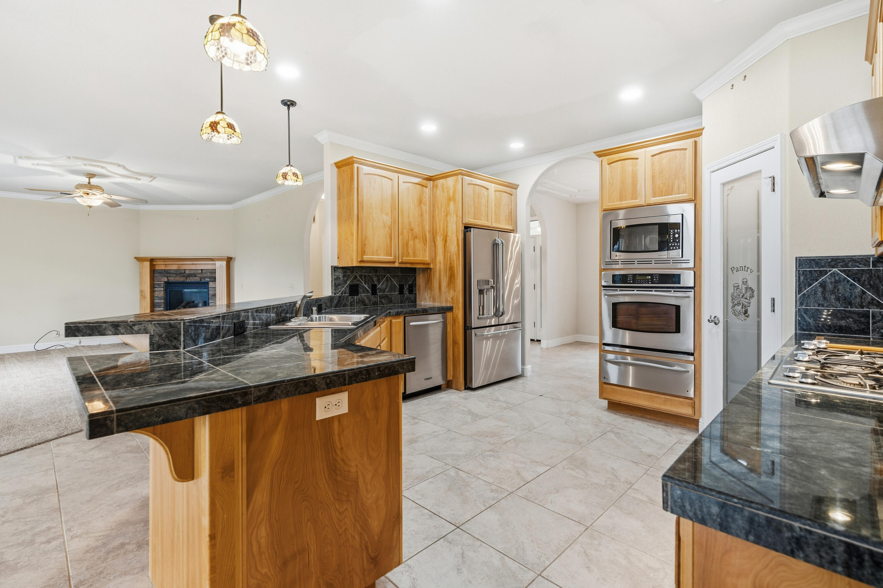 14535 Molluc Drive Red Bluff, CA 96080 - Photo 9 of 72 a kitchen with kitchen island granite countertop a sink appliances cabinets and furniture