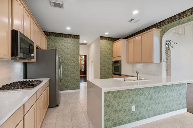 a kitchen with kitchen island granite countertop a sink stove and refrigerator