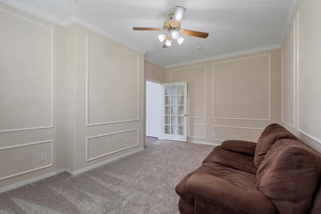 a living room with furniture and a ceiling fan