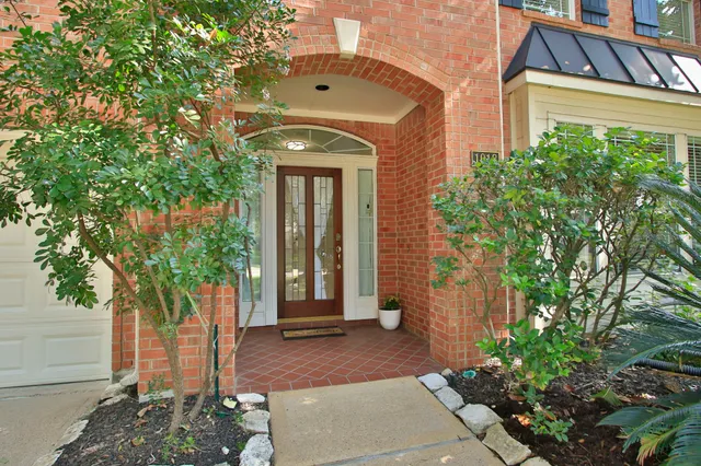 a front view of a house with a tree