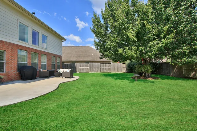 a view of a house with backyard and a tree