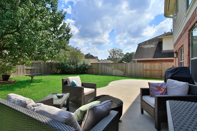 a view of a patio with couches table and chairs with wooden fence