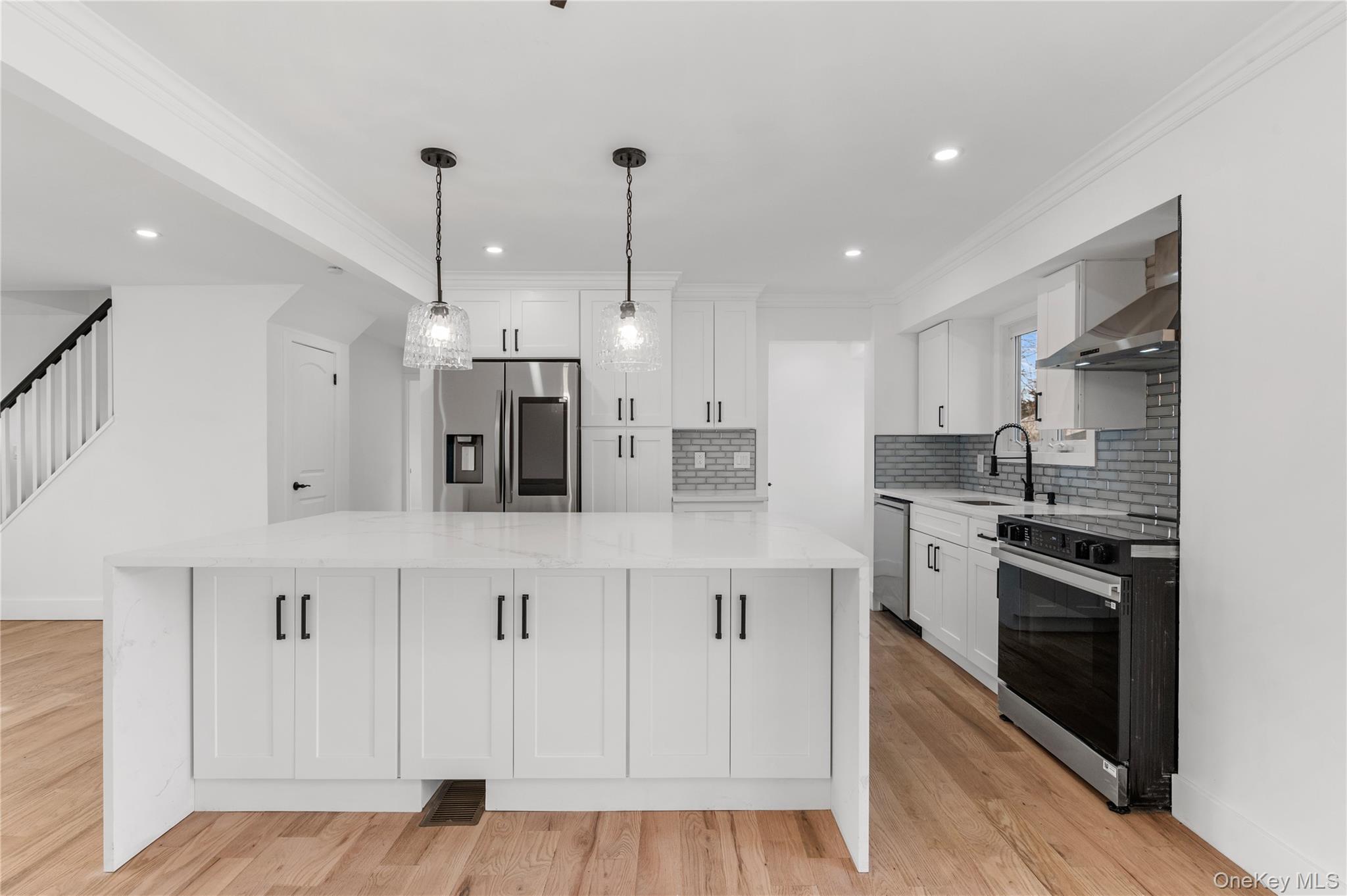 19 Hicks Avenue Syosset, NY 11791 - Photo 7 of 30 a kitchen with stainless steel appliances kitchen island granite countertop a stove a sink and white cabinets