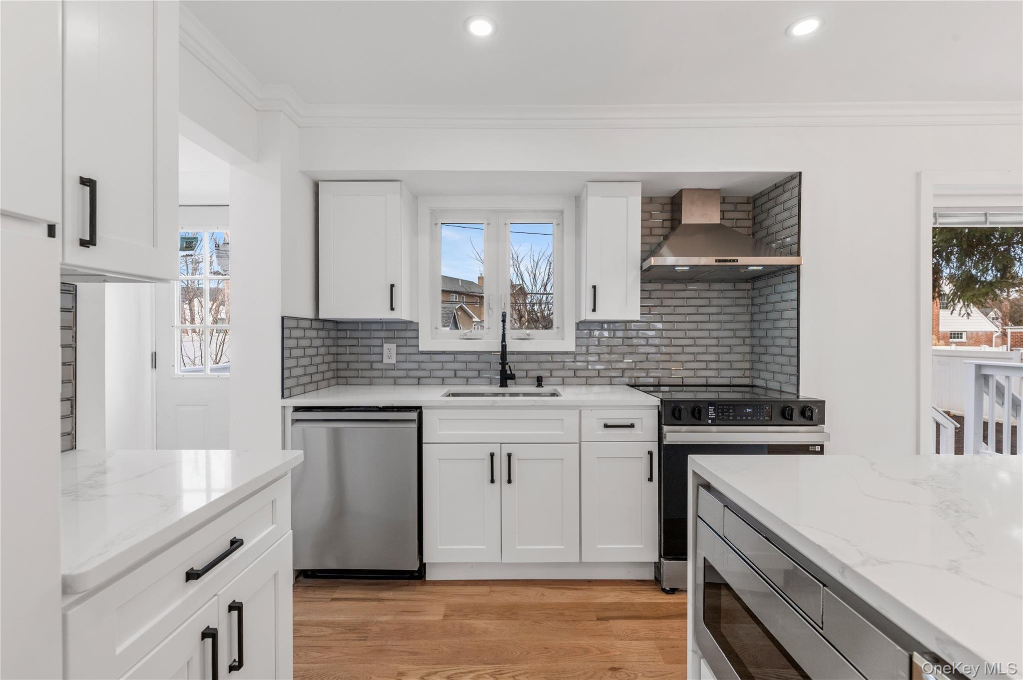 19 Hicks Avenue Syosset, NY 11791 - Photo 8 of 30 a kitchen with stainless steel appliances granite countertop a sink stove and refrigerator