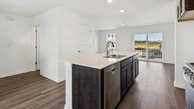 a kitchen with a sink stove and wooden floor