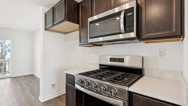 a kitchen with stainless steel appliances granite countertop a stove microwave and sink