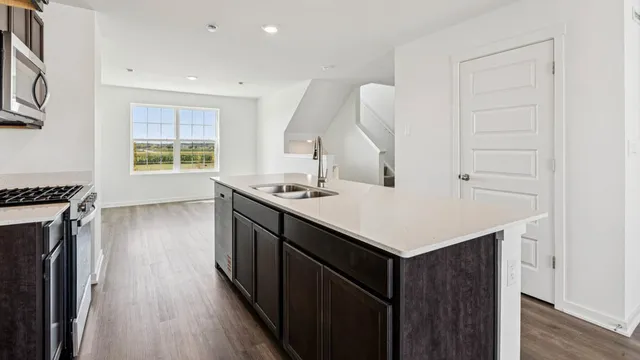 a kitchen with a sink cabinets and wooden floor