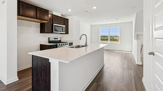 a kitchen with a sink a microwave and cabinets