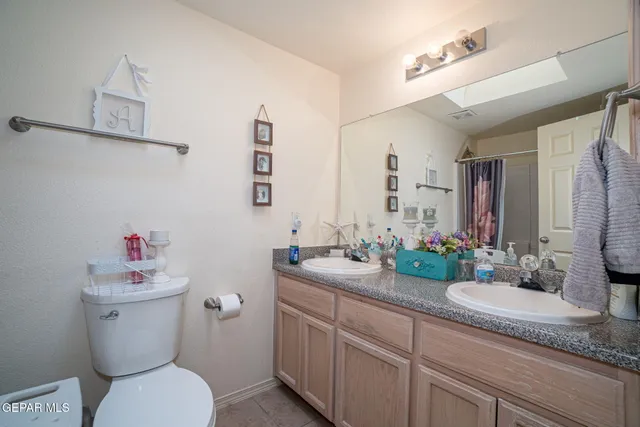 a bathroom with a granite countertop sink mirror vanity and toilet