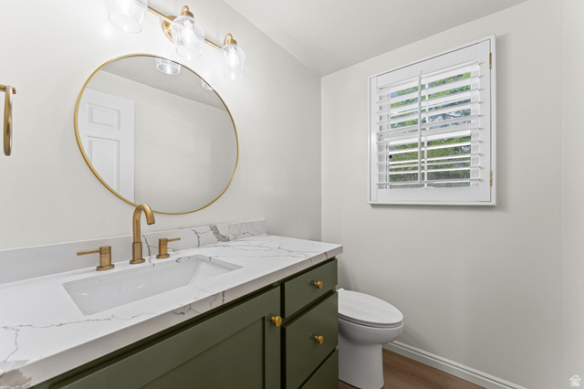 8441 Rua Branco Drive Sandy, UT 84093 - Photo 22 of 47 Elegant bathroom vanity featuring a dark green cabinetry base with brass hardware, white marble countertop, and an integrated rectangular sink