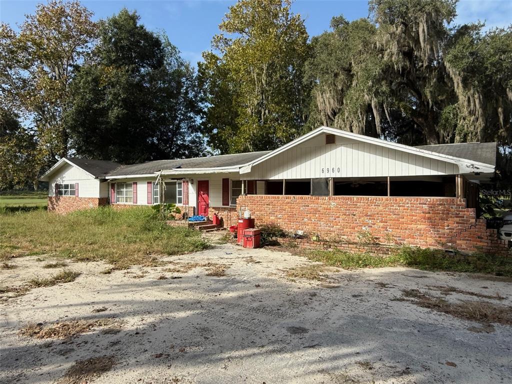 6910 Northwest 35th Avenue Road Ocala, FL 34475 - Photo 5 of 8 a front view of a house with a yard outdoor seating and covered with trees