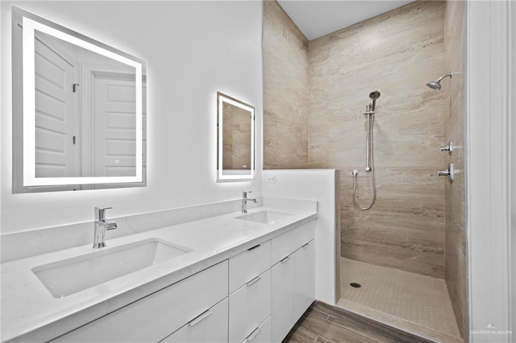 2716 East Conroe Road Edinburg, TX 78542 - Photo 15 of 31 Full bath with a walk in shower, double vanity, and light wood finished floors