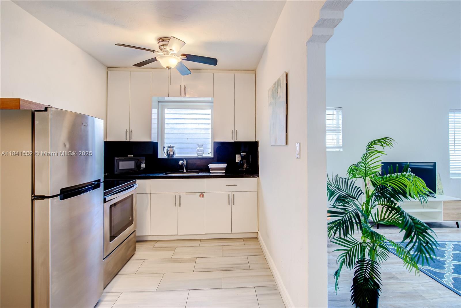 855 Southwest 7th Street, Unit 3 Miami, FL 33130 - Photo 12 of 18 a kitchen with stainless steel appliances a refrigerator a sink a stove a faucet a potted plant a counter top space and cabinets