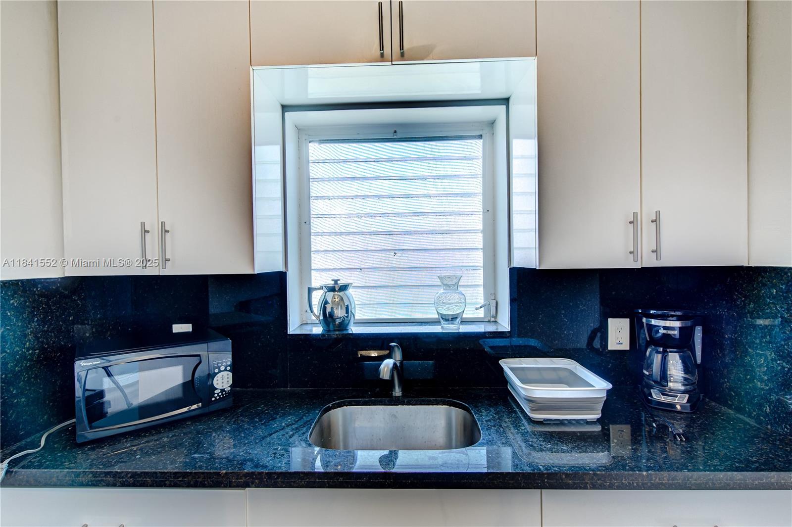 855 Southwest 7th Street, Unit 3 Miami, FL 33130 - Photo 13 of 18 a kitchen with granite countertop a sink dishwasher a stove and a microwave oven