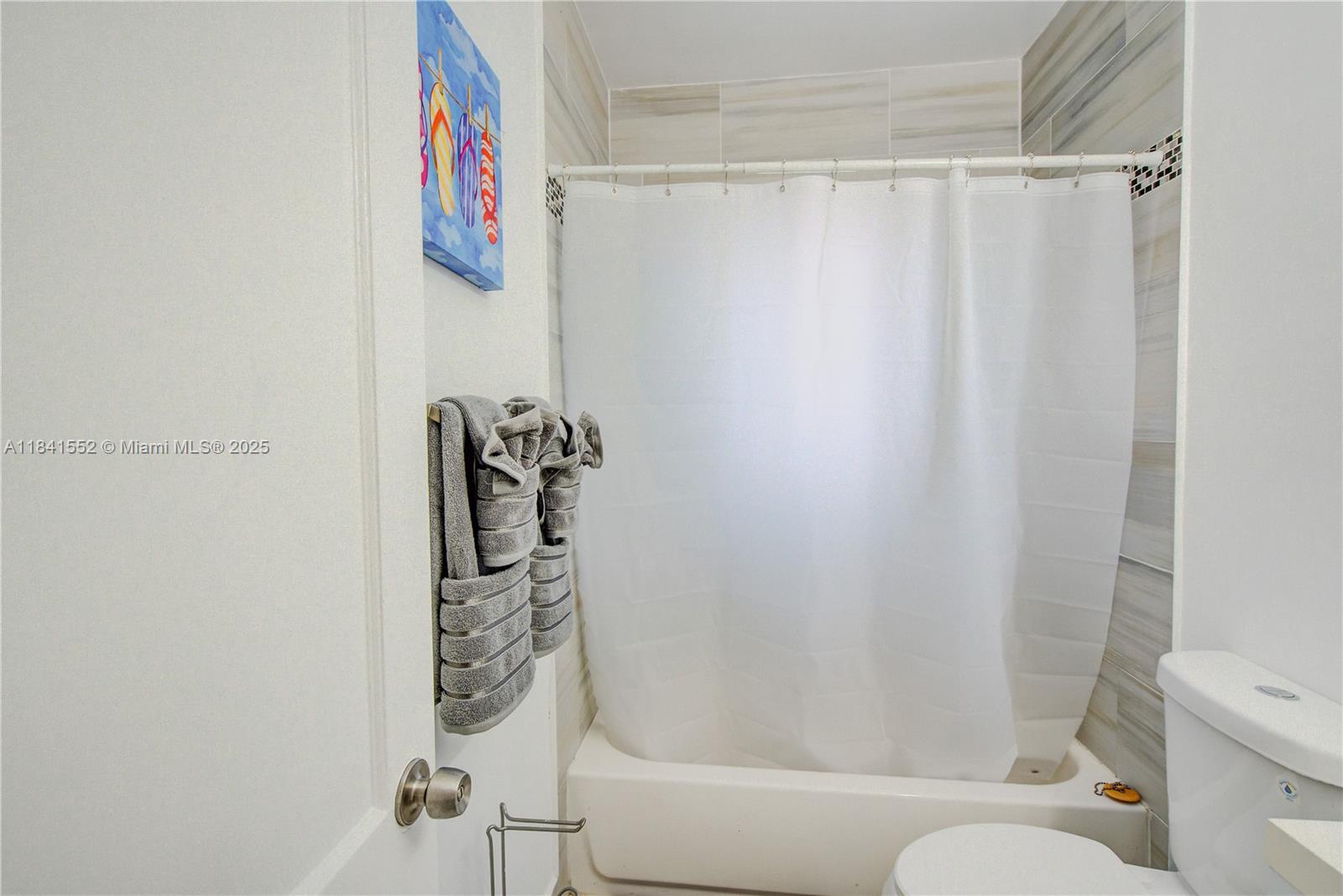 855 Southwest 7th Street, Unit 3 Miami, FL 33130 - Photo 17 of 18 a bathroom with a shower curtain and a toilet