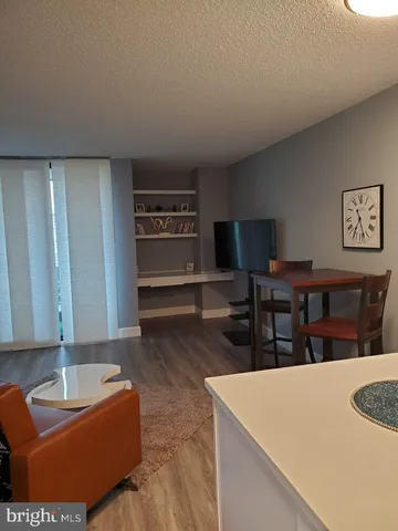 a living room with furniture a flat screen tv and a table