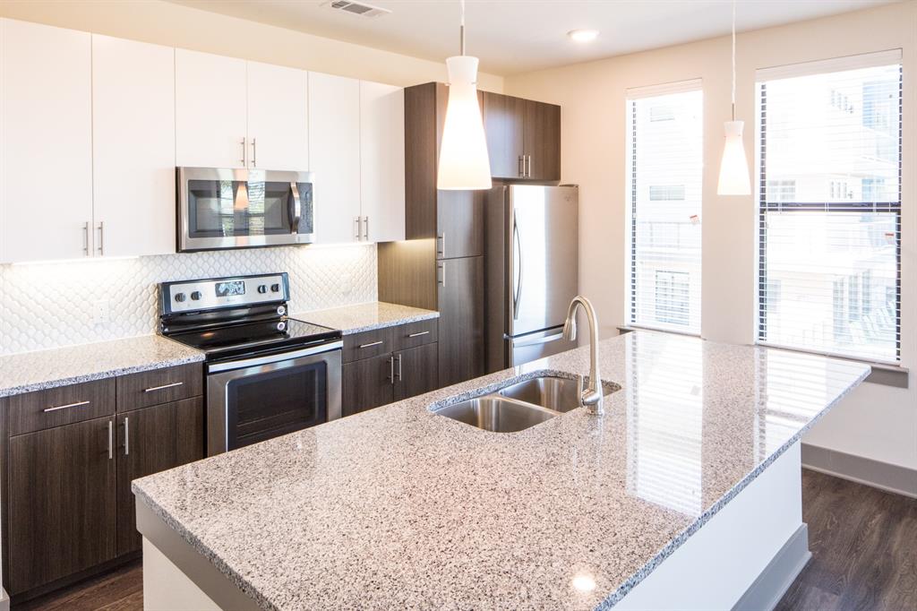 2175 Tucker Street, Unit 2102 Dallas, TX 75214 - Photo 6 of 7 a kitchen with stainless steel appliances granite countertop a refrigerator a stove and a sink with wooden floor