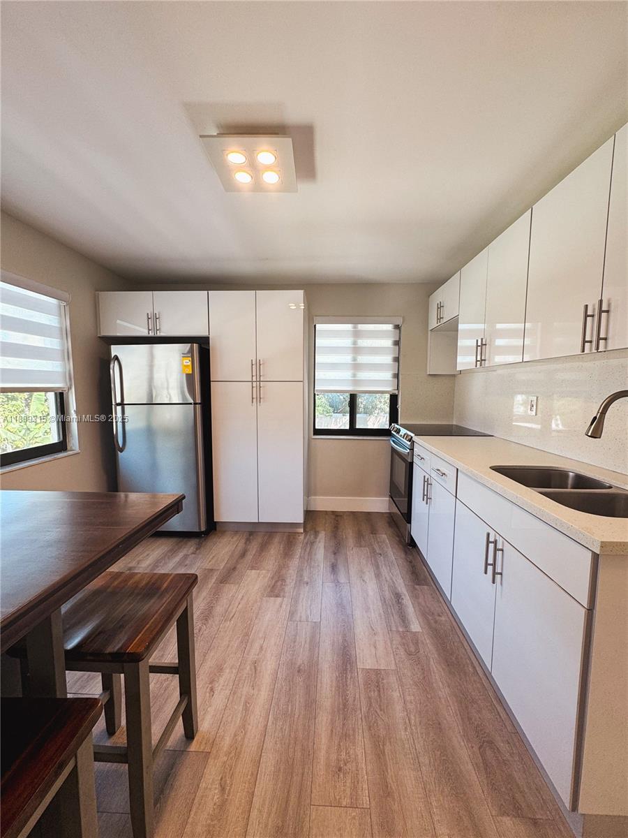 851 East 17th Street, Unit B Hialeah, FL 33010 - Photo 12 of 13 a kitchen with a wooden floor and a window