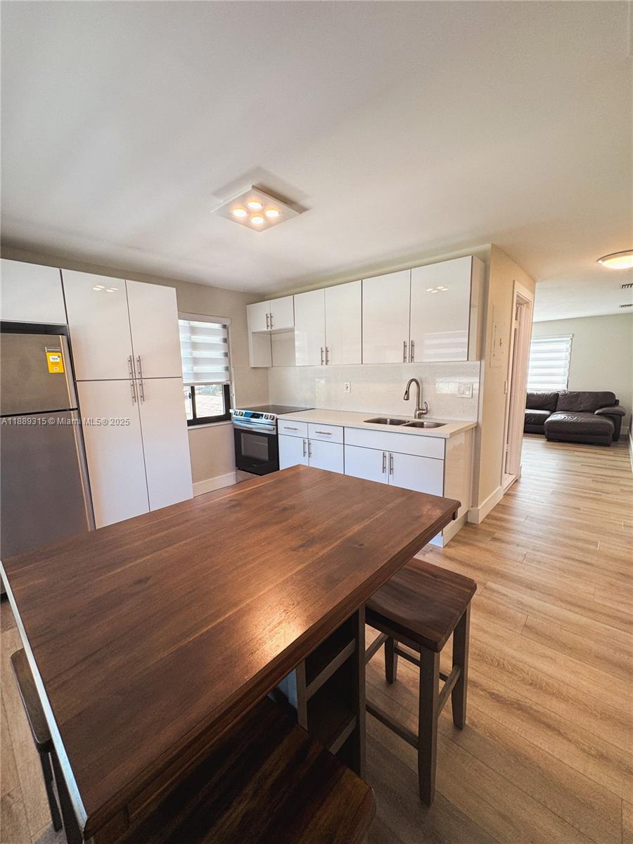 851 East 17th Street, Unit B Hialeah, FL 33010 - Photo 13 of 13 a kitchen with kitchen island a stove and a refrigerator