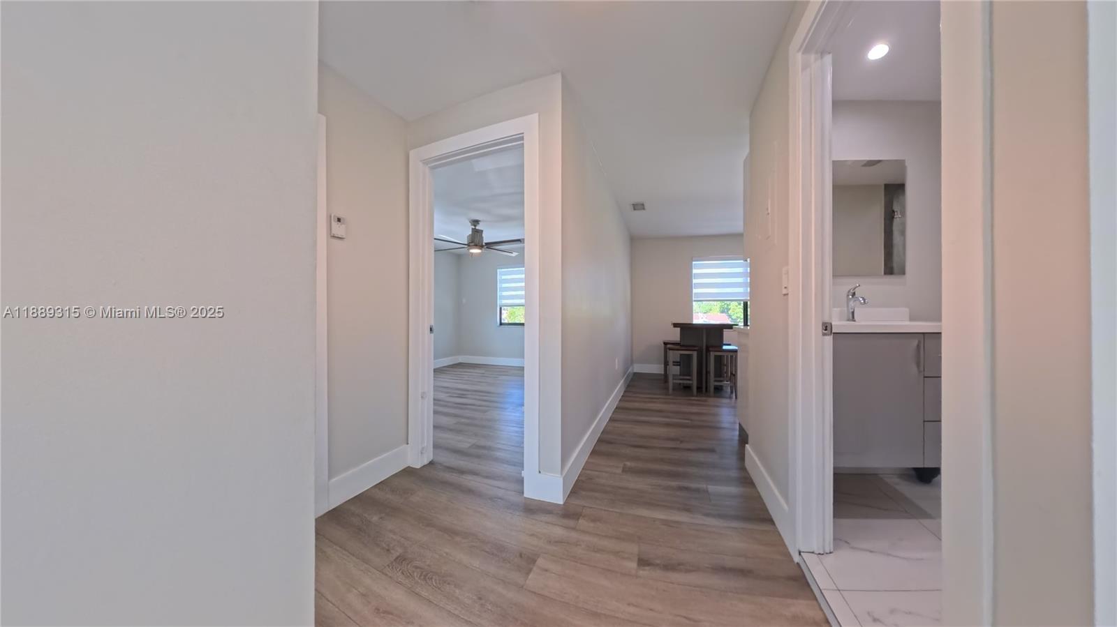 851 East 17th Street, Unit B Hialeah, FL 33010 - Photo 5 of 13 a view of a hallway with wooden floor and a bathroom