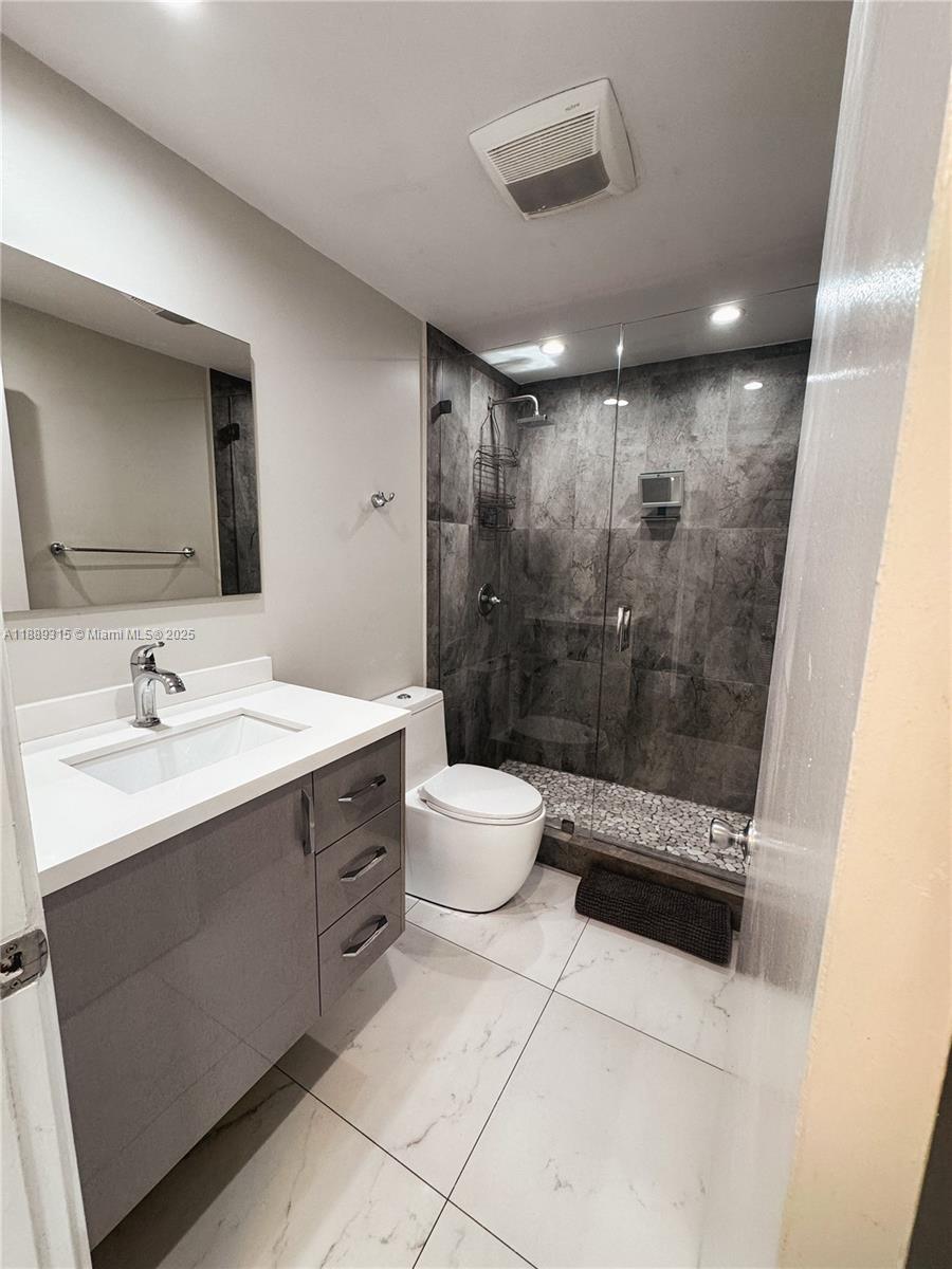 851 East 17th Street, Unit B Hialeah, FL 33010 - Photo 10 of 13 a bathroom with a double vanity sink toilet and shower