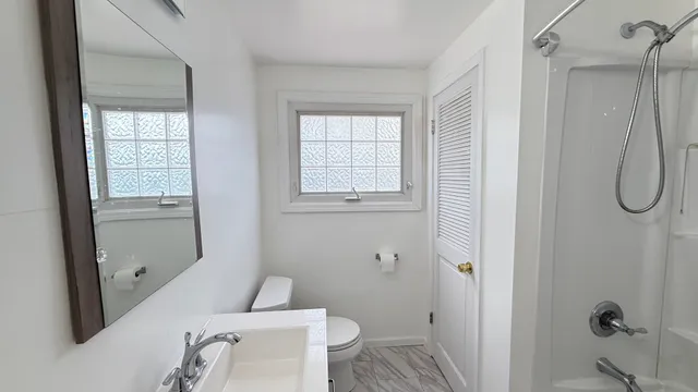 a bathroom with a granite countertop sink toilet and shower