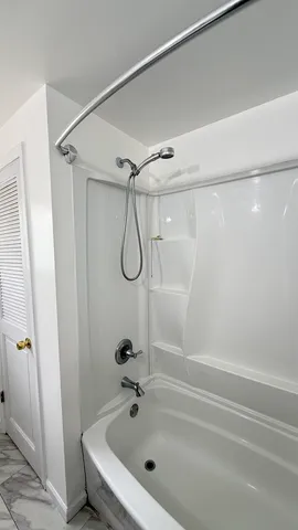 a bathroom with a bath tub with a shower