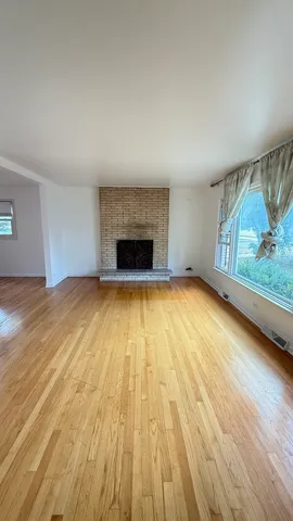 wooden floor in an empty room with a fireplace
