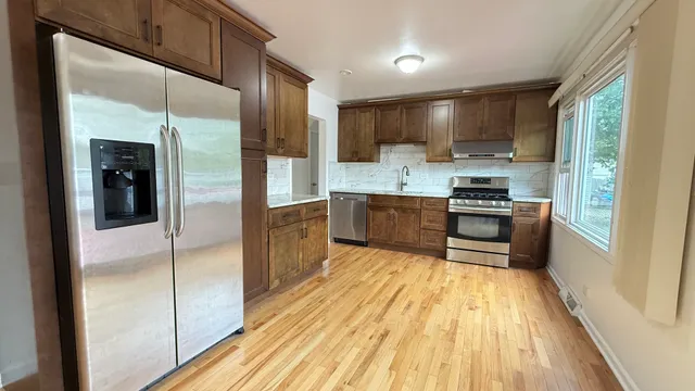 a kitchen with stainless steel appliances granite countertop a refrigerator and a sink