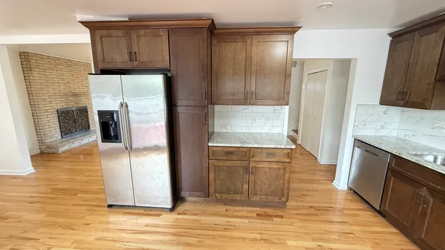 a view of a kitchen with wooden floor and a refrigerator
