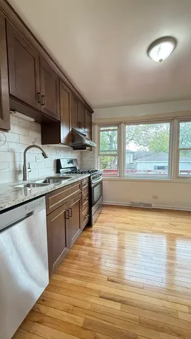 a kitchen with stainless steel appliances granite countertop a sink stove and cabinets
