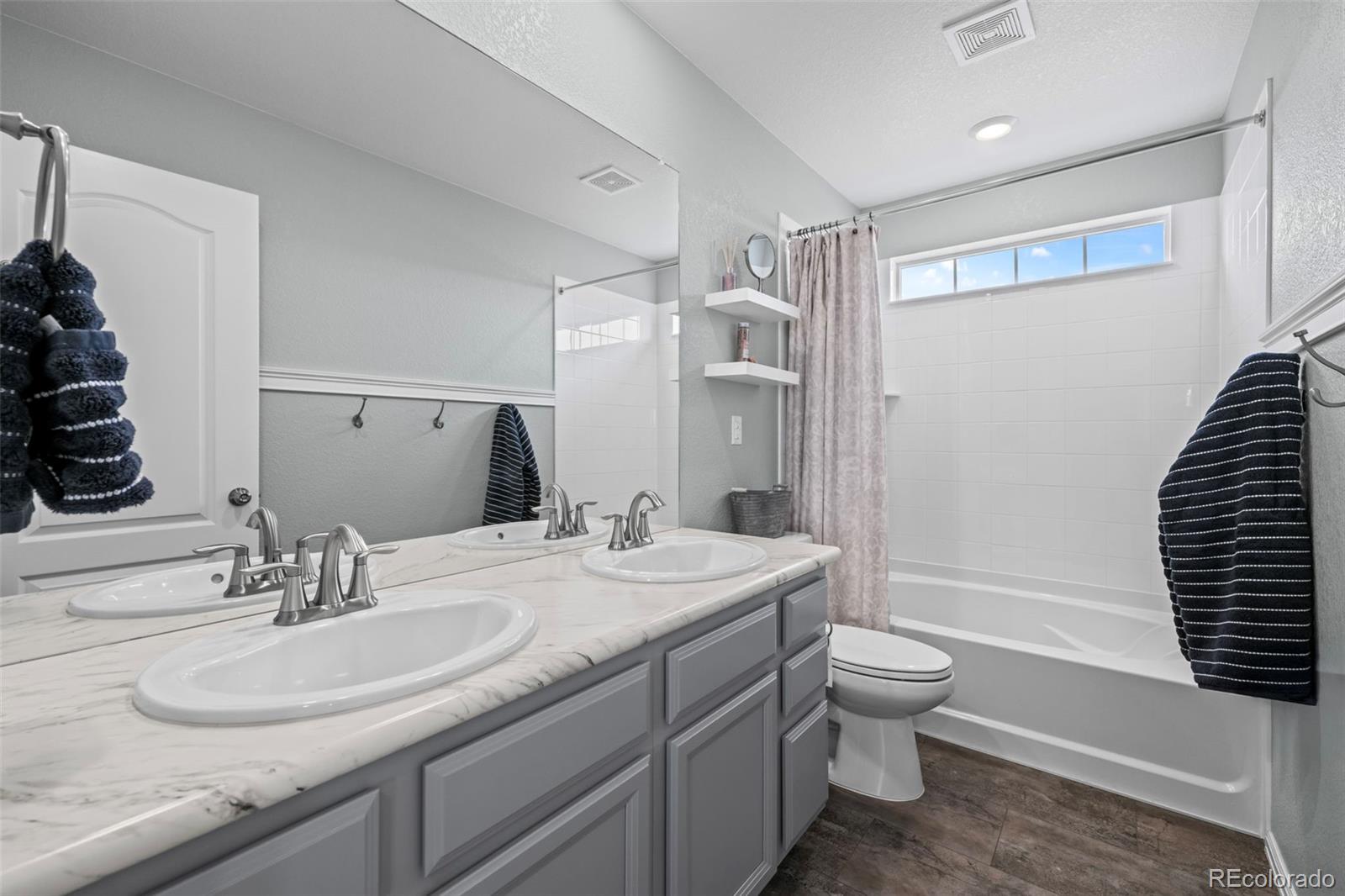 10985 Wheeling Street Commerce City, CO 80022 - Photo 19 of 45 a bathroom with a double vanity sink toilet and shower