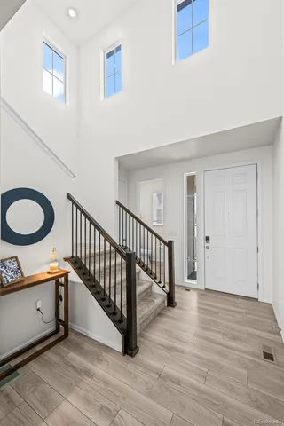 a view of a hallway with wooden floor and staircase