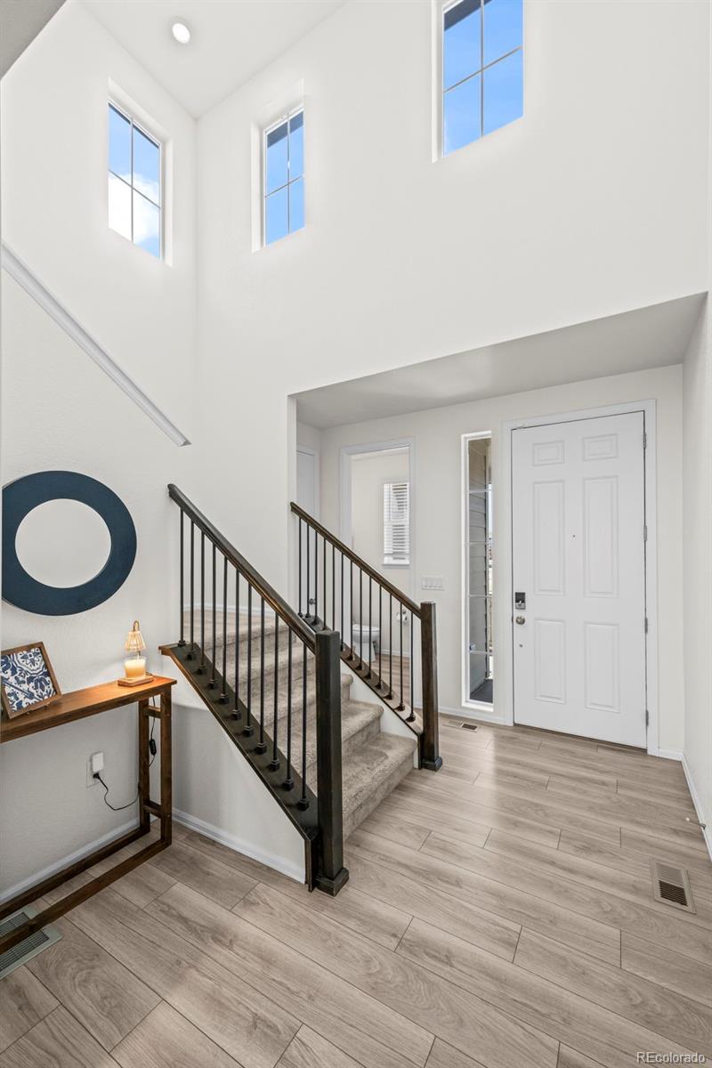 10985 Wheeling Street Commerce City, CO 80022 - Photo 3 of 45 a view of a hallway with wooden floor and staircase