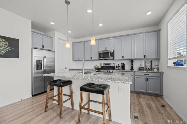 a kitchen with kitchen island white cabinets and stainless steel appliances