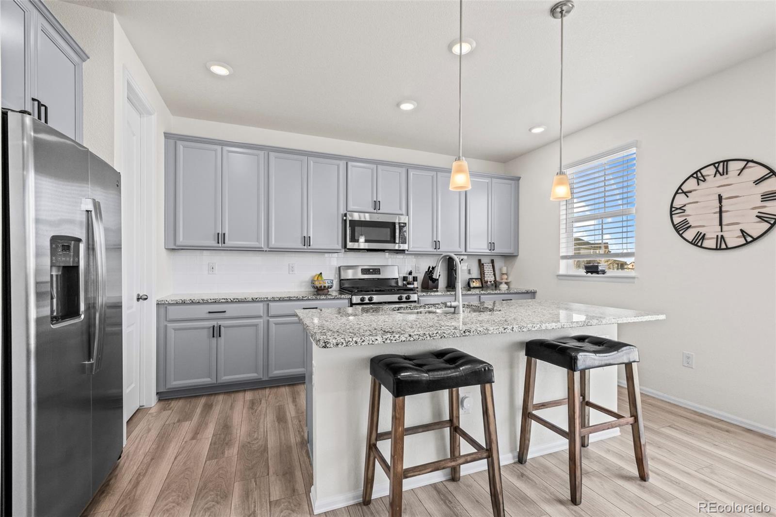 10985 Wheeling Street Commerce City, CO 80022 - Photo 10 of 45 a kitchen with stainless steel appliances granite countertop a stove top oven a refrigerator a sink and dishwasher with white cabinets