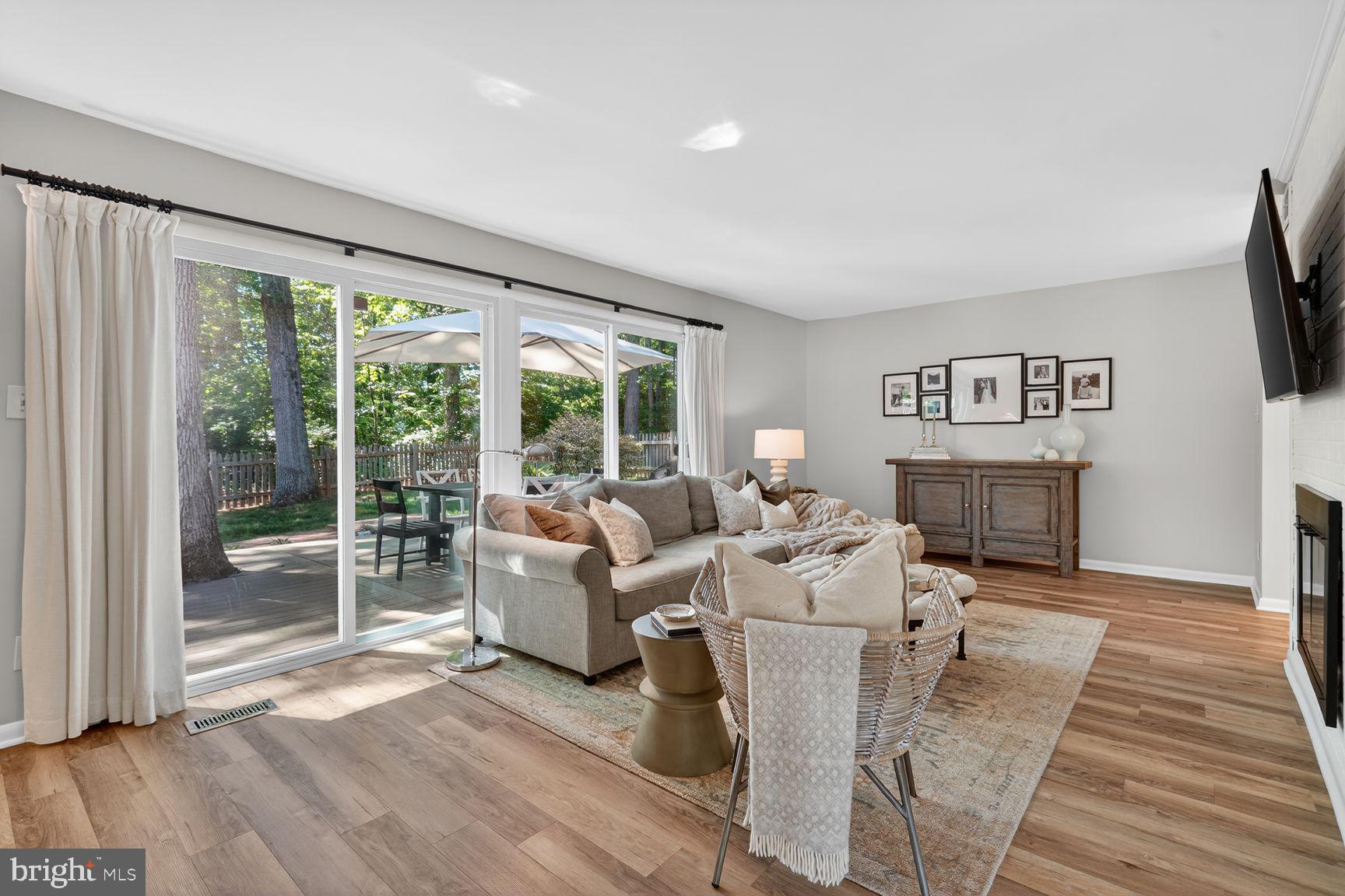 11201 Wedge Drive Reston, VA 20190 - Photo 4 of 31 a living room with furniture a flat screen tv and a floor to ceiling window